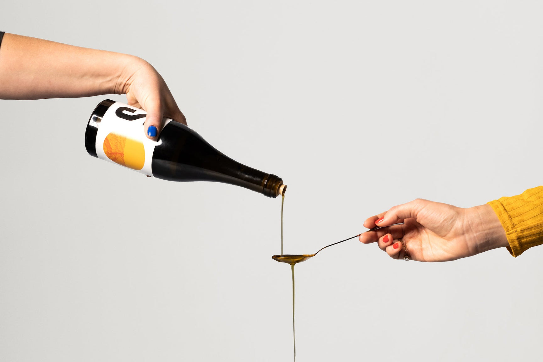 Pouring a spoon of extra virgin olive oil