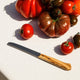 Assorted tomatoes with a nonna knife on a light surface