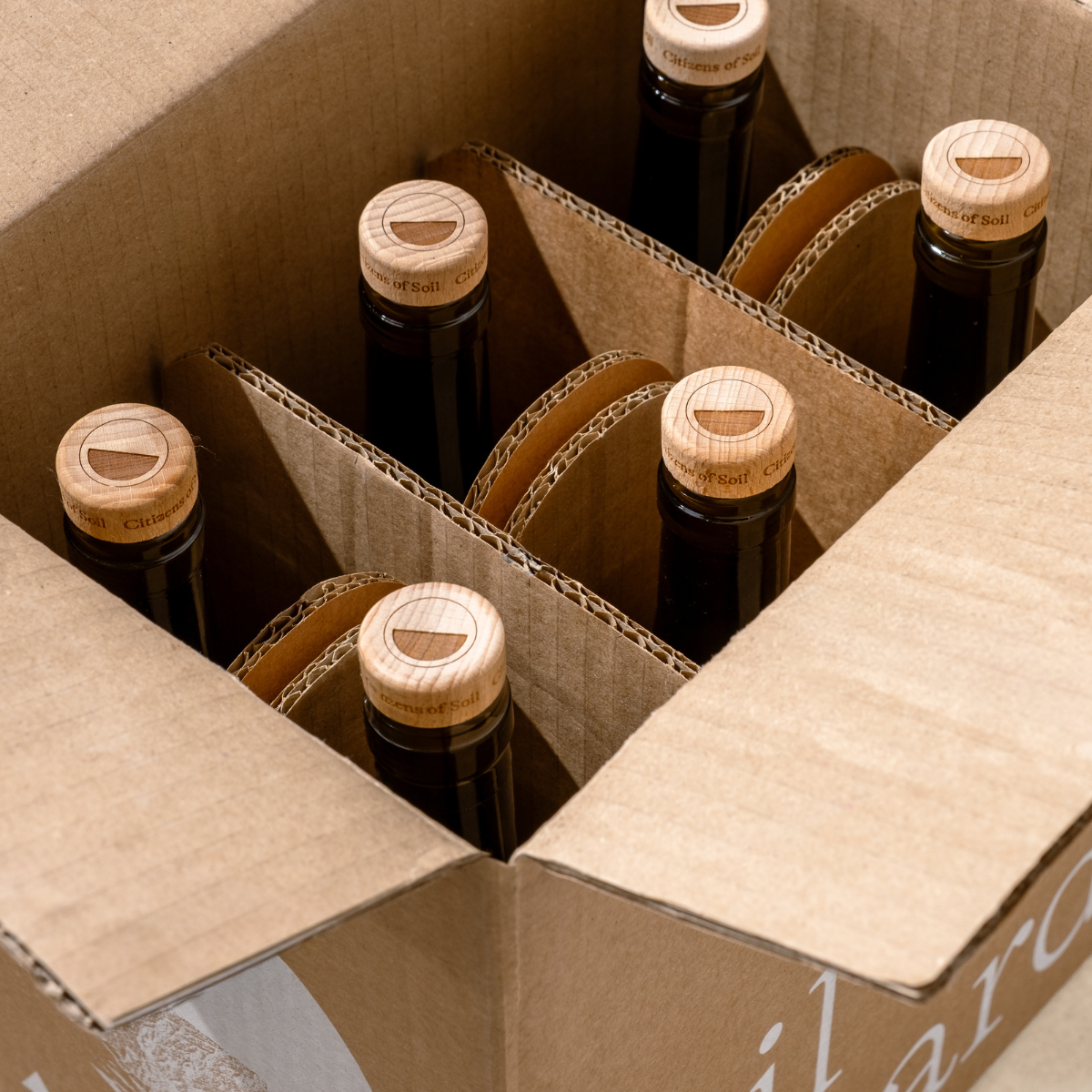 Bottles with wooden caps in a cardboard box