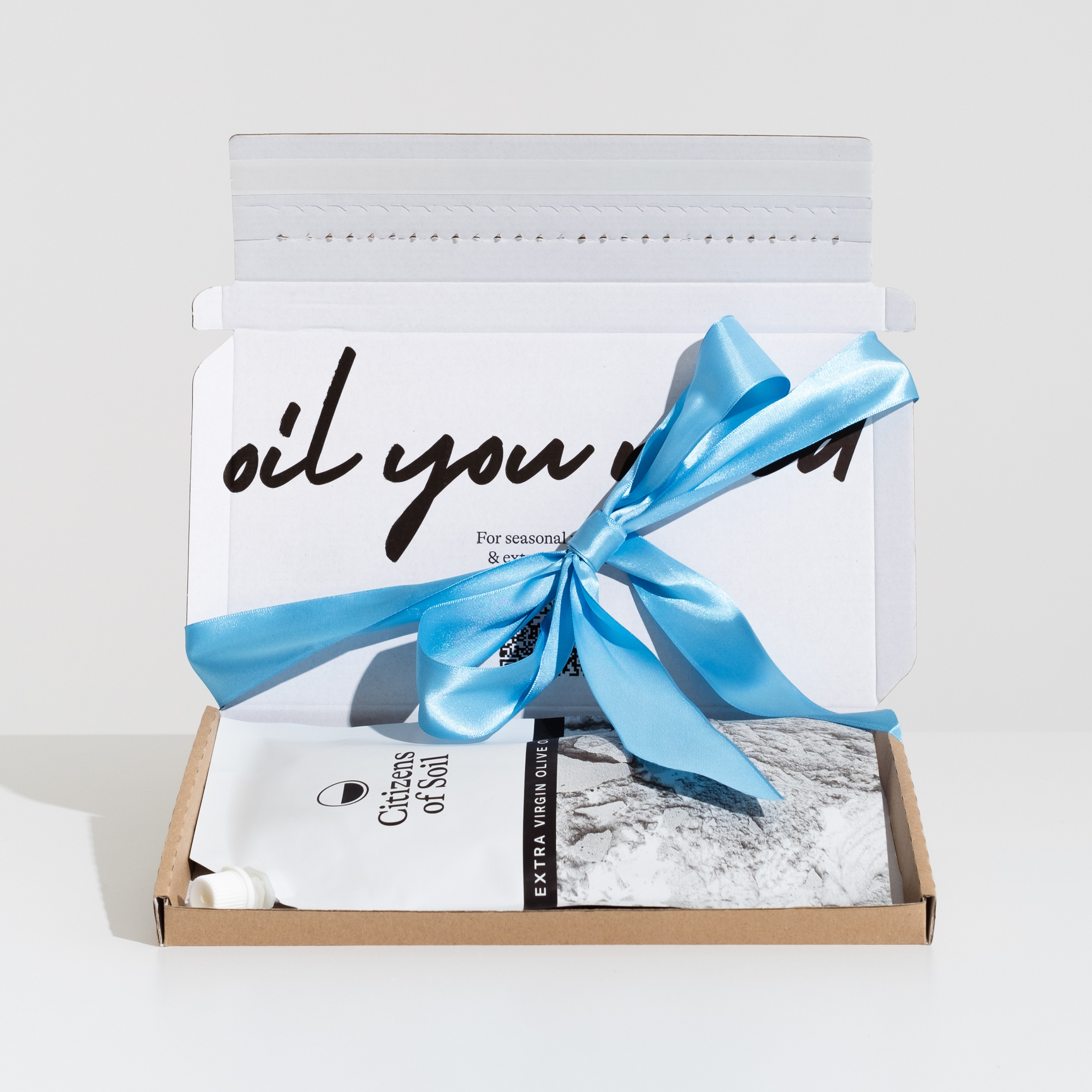 Citizens of Soil olive oil pouch in open letter box parcel with blue ribbon bow