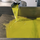 Fresh olive oil juice coming out of spout in factory